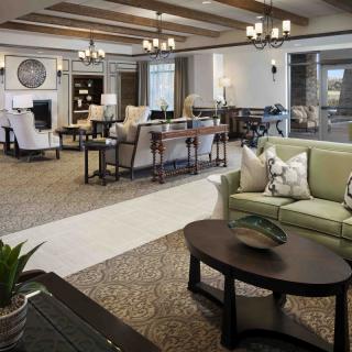 A spacious and elegantly designed living room with comfortable seating, stylish decor, and ambient lighting.