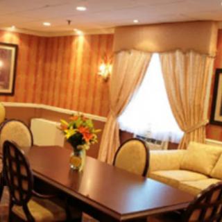 A warmly lit dining room with a wooden table, chairs, and elegant decor.