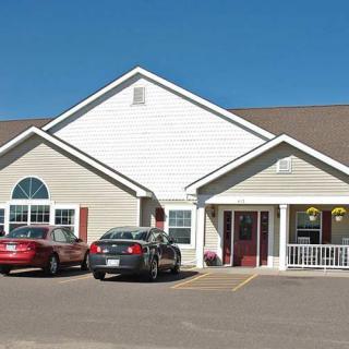 A residential building with parked cars in front.