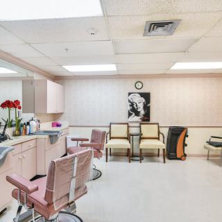 A modern beauty salon with pink chairs, mirrors, and a stylish interior.