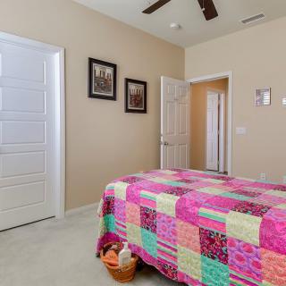 A cozy bedroom with a colorful quilt and simple decor.