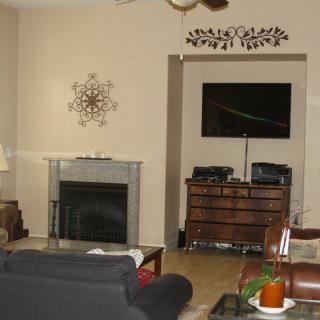 A cozy living room with a fireplace, television, and comfortable seating.