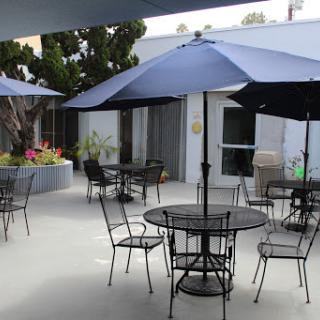 A serene outdoor patio area with tables and umbrellas, ideal for relaxation and social gatherings.