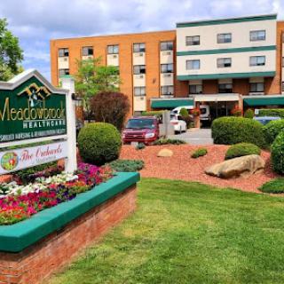 A welcoming view of the hotel entrance, featuring vibrant flowers and a well-maintained lawn.