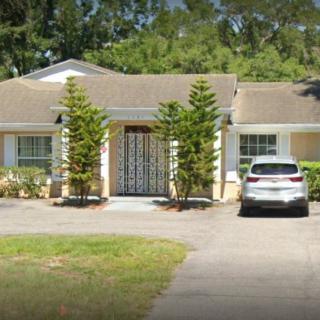 A suburban house with a driveway and a parked car in front.