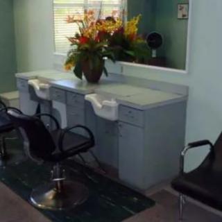 A small salon interior with styling chairs and a mirror.