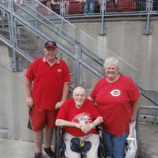 Group of fans in red clothing posing at a stadium.