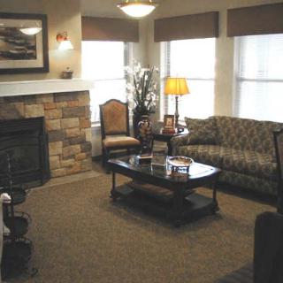 A cozy living room with a sofa, coffee table, and fireplace.