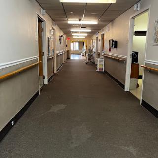 A view of a well-lit hallway in a healthcare facility.