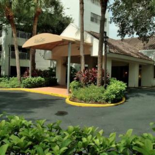 A well-maintained building entrance with an awning and landscaped surroundings.