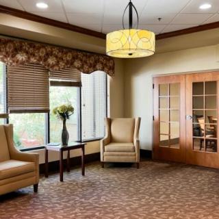 A cozy waiting room with comfortable chairs and a small table topped with a flower vase.