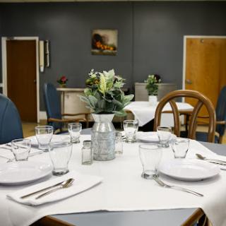 A beautifully arranged dining area with a well-set table, fresh flowers in a vase, and an inviting atmosphere.