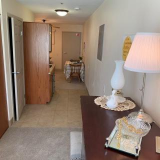 A well-lit hallway with decorative furnishings and a table lamp.