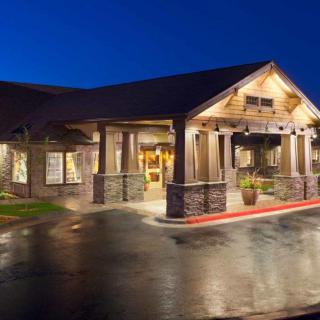 A well-lit building entrance at night with a rustic architectural style.