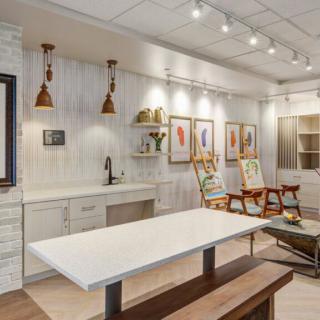 A modern art studio with paintings, workspaces, and stylish lighting.
