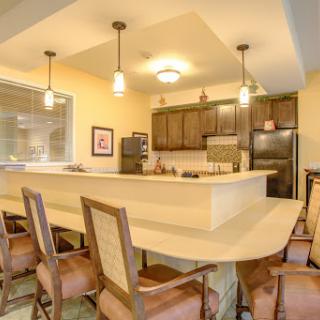 A modern kitchen featuring a spacious dining area with stylish chairs and contemporary appliances.