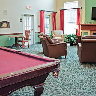 A cozy game room with a pool table and seating area.