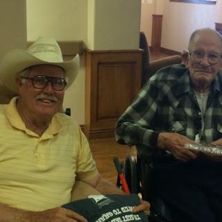 Two elderly men enjoying each other's company in a relaxed indoor setting.