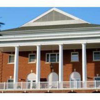 A classical building with tall columns and brick facade.