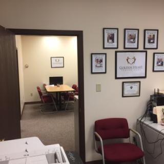 A view of an office space showing a meeting room and decorated walls.