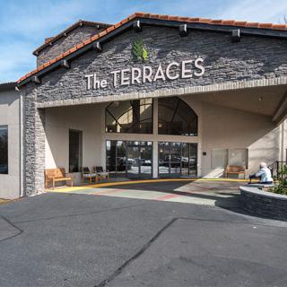 The entrance of 'The Terraces' showcasing its stone facade and welcoming design.