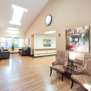 A cozy waiting area with comfortable chairs, a piece of artwork, and ample natural light.
