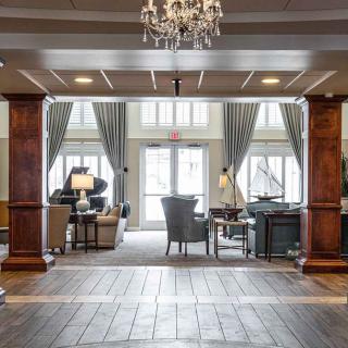 Spacious and elegant living room with large windows and a chandelier.