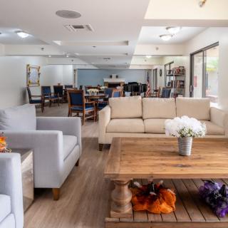 A modern living room with comfortable sofas and a wooden coffee table, decorated with flowers.