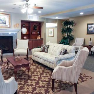 A cozy living room with a sofa, armchairs, and a fireplace.