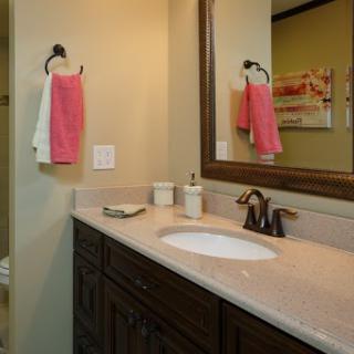 A cozy and well-lit bathroom featuring a stylish vanity, sink, and colorful towels.