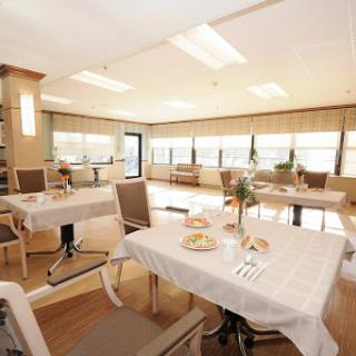 A bright and modern dining area with neatly set tables, creating a welcoming atmosphere.