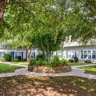 A serene garden area with trees and pathways in a residential setting.
