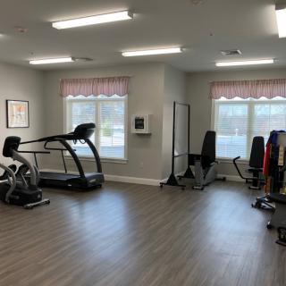A spacious gym area equipped with exercise machines and a treadmill.