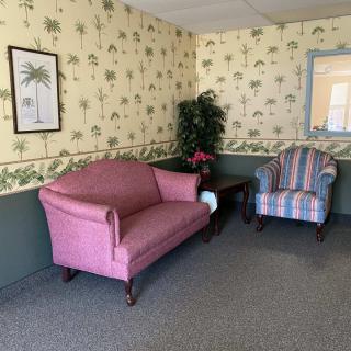 Cozy living room with a pink sofa and striped armchair.