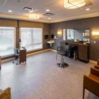 A modern hair salon interior with chairs, mirrors, and ample natural lighting.