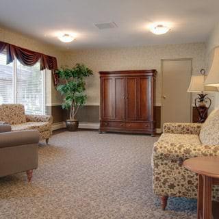 A cozy living room with comfortable seating, a wooden cabinet, and soft lighting.