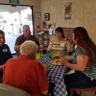 A group of people enjoying a meal together indoors at a table.