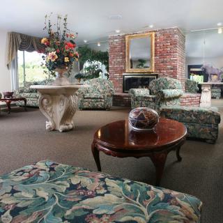 A traditional living room with floral-patterned furniture and a brick fireplace.