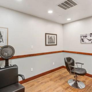 A well-appointed hair salon interior with a styling chair and hair dryer.
