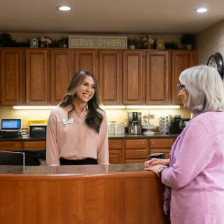 A receptionist warmly engages with a customer at a welcoming front desk.