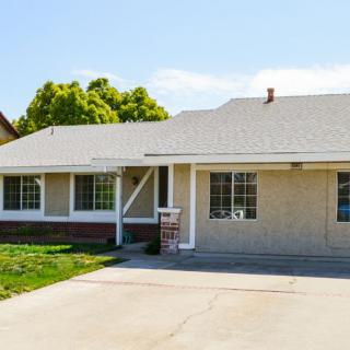 A single-story suburban house with a driveway and a small front yard.