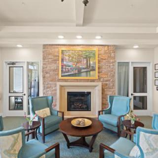 A cozy living room seating area with a fireplace and elegant decor.