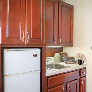 Compact kitchen setup with wooden cabinets and a white refrigerator.