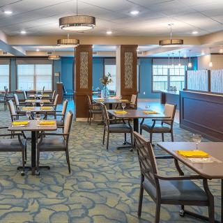 A modern and empty restaurant dining area with neatly arranged tables and chairs.