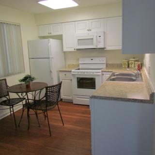 A modern kitchen with a dining table and essential appliances.