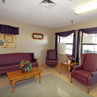 A cozy living room with purple furniture and wooden tables.