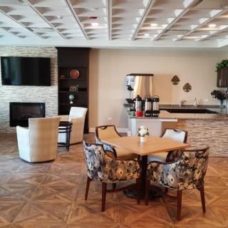 A modern lounge area featuring a seating arrangement, coffee station, and television.