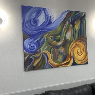 A colorful abstract painting with swirling patterns on a wall.