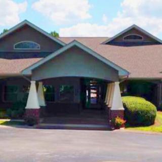 A residential-style building with a covered entrance and a driveway.