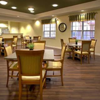 A cozy dining area with neatly arranged tables and chairs on a wooden floor.